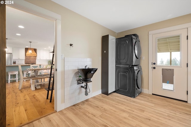 interior space featuring stacked washer / drying machine and light hardwood / wood-style floors