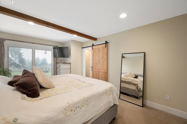 bedroom with beam ceiling, a barn door, and light colored carpet