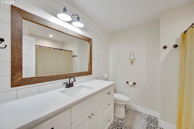 bathroom featuring tile patterned flooring, vanity, toilet, and walk in shower