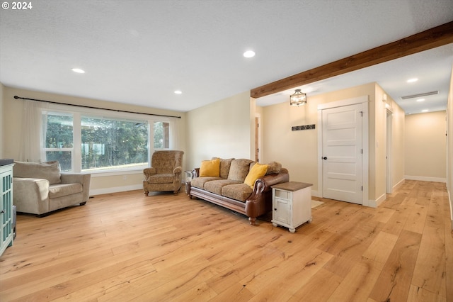 living room featuring beam ceiling and light hardwood / wood-style flooring