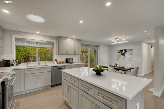 kitchen featuring a healthy amount of sunlight, appliances with stainless steel finishes, sink, and a kitchen island