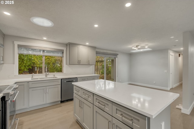 kitchen with stainless steel appliances, sink, a kitchen island, and a wealth of natural light