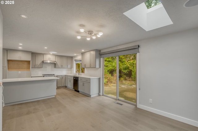 kitchen featuring gray cabinets, black dishwasher, sink, and light wood-type flooring