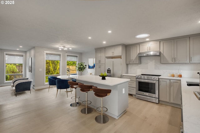 kitchen featuring gray cabinets, stainless steel appliances, light hardwood / wood-style floors, and a kitchen island