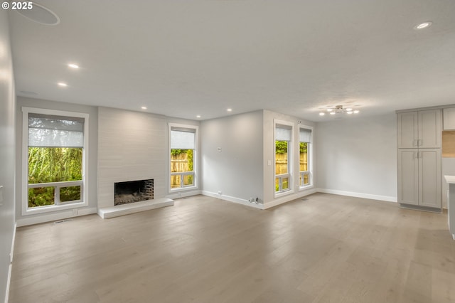 unfurnished living room featuring light hardwood / wood-style flooring and a high end fireplace