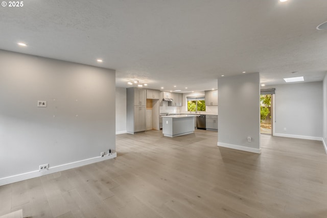 unfurnished living room featuring light hardwood / wood-style flooring and a textured ceiling