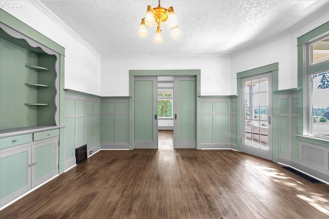 unfurnished dining area with a chandelier, dark hardwood / wood-style flooring, and a textured ceiling