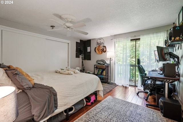 bedroom featuring a textured ceiling, access to outside, wood-type flooring, and ceiling fan