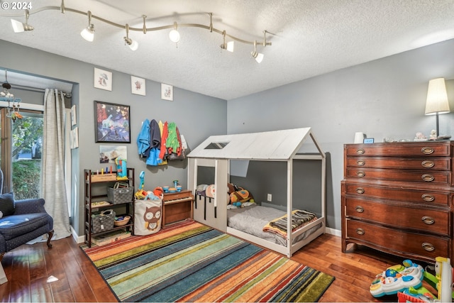 bedroom featuring a textured ceiling and light hardwood / wood-style flooring