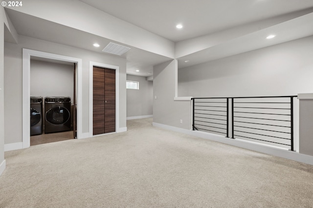 basement featuring light carpet and separate washer and dryer