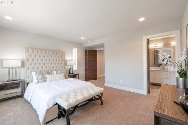 carpeted bedroom with connected bathroom and sink