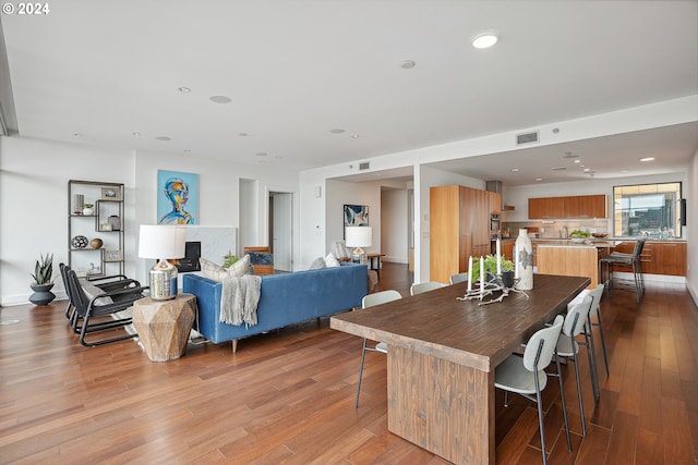 dining room featuring a premium fireplace and light hardwood / wood-style flooring