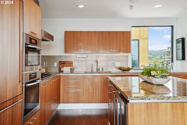 kitchen featuring sink, backsplash, wine cooler, and light stone counters