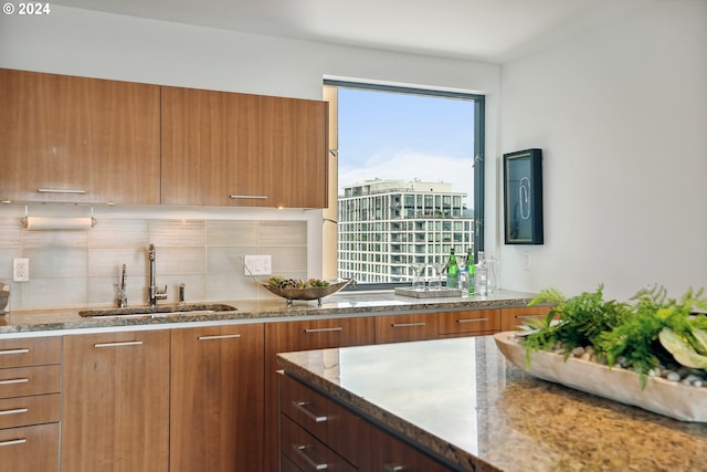 kitchen with tasteful backsplash, sink, and light stone counters