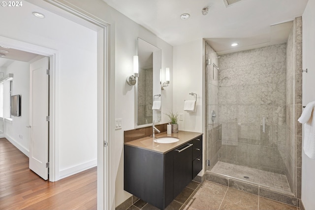 bathroom featuring hardwood / wood-style flooring, vanity, and a shower with door