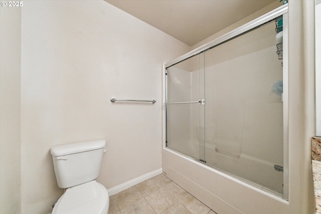 bathroom featuring tile patterned flooring, shower / bath combination with glass door, and toilet