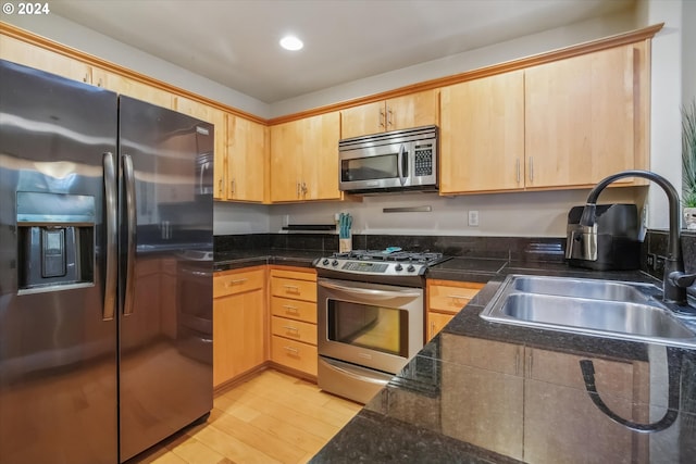 kitchen featuring appliances with stainless steel finishes, light hardwood / wood-style floors, sink, and light brown cabinets