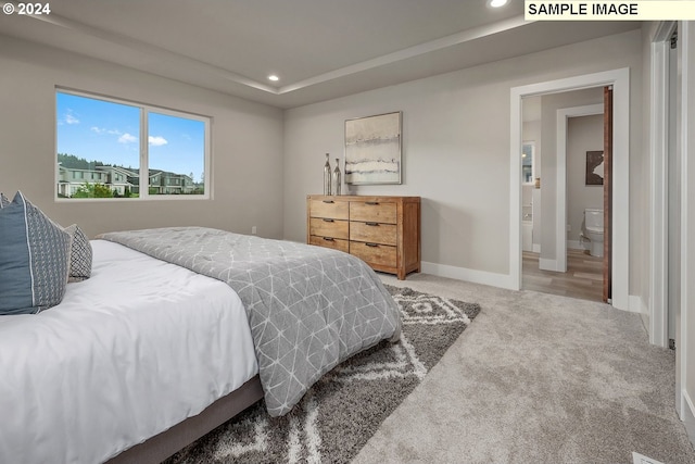 bedroom with connected bathroom and carpet floors