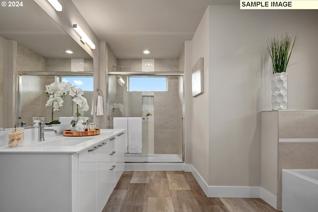 bathroom featuring walk in shower, vanity, and hardwood / wood-style flooring