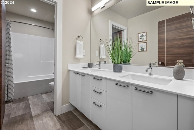 full bathroom featuring shower / bath combo, hardwood / wood-style floors, vanity, and toilet