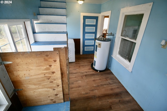 kitchen featuring water heater, washer / clothes dryer, and dark hardwood / wood-style flooring