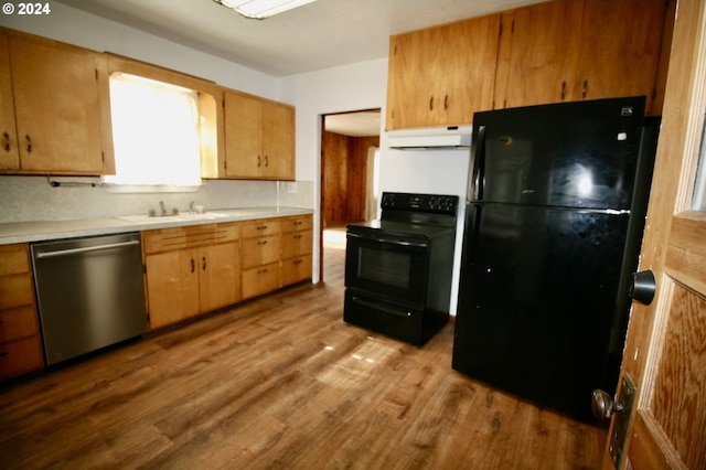 kitchen with black appliances, sink, light hardwood / wood-style flooring, and tasteful backsplash