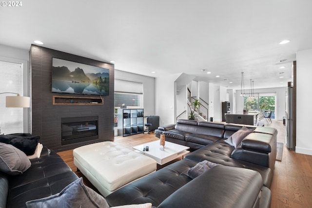 living room with hardwood / wood-style flooring, a large fireplace, and sink