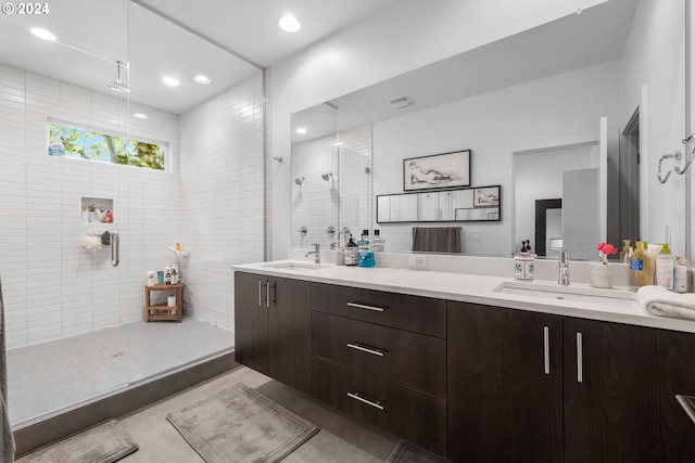 bathroom with a tile shower, tile patterned flooring, and vanity