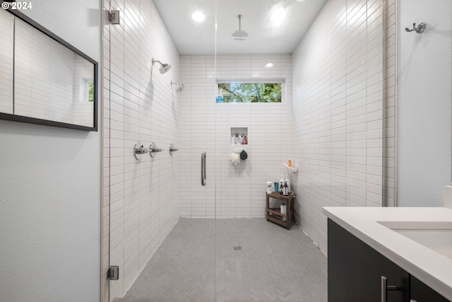 bathroom featuring vanity, an enclosed shower, and tile walls