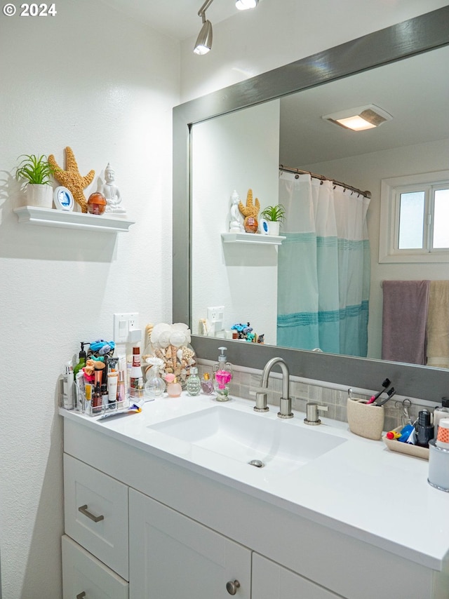 bathroom with tasteful backsplash and vanity