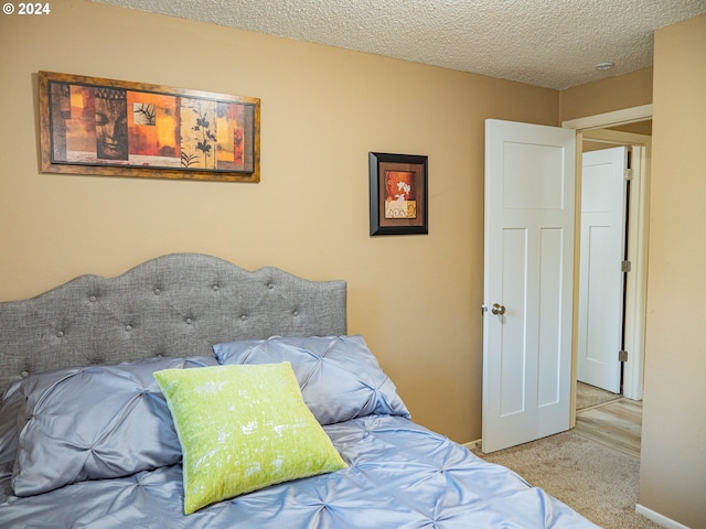 bedroom featuring carpet flooring and a textured ceiling