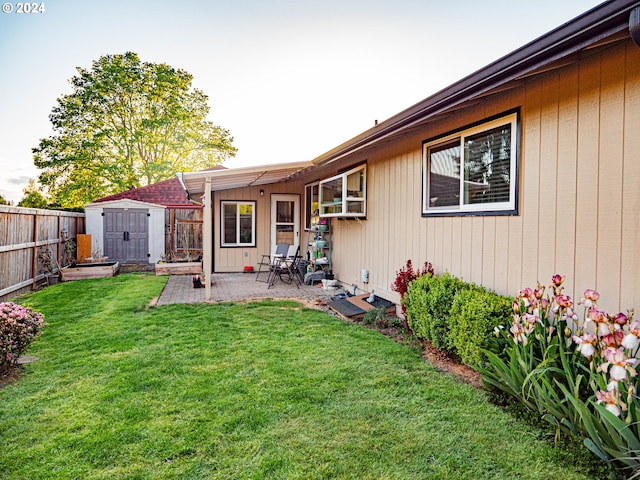 rear view of property featuring a patio area, a shed, and a yard