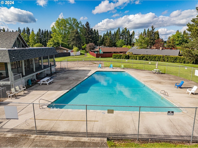 view of swimming pool with a patio and a yard