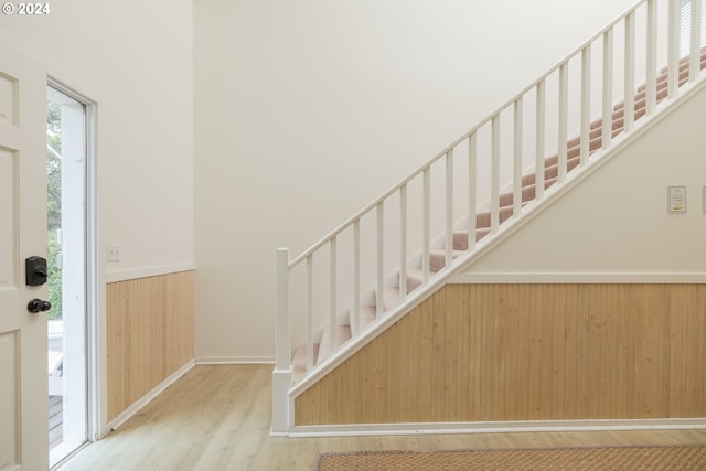 entrance foyer with light hardwood / wood-style floors and wood walls