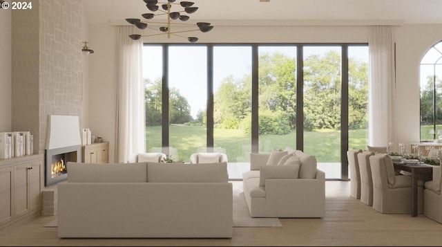 interior space with an inviting chandelier, light hardwood / wood-style flooring, and a large fireplace