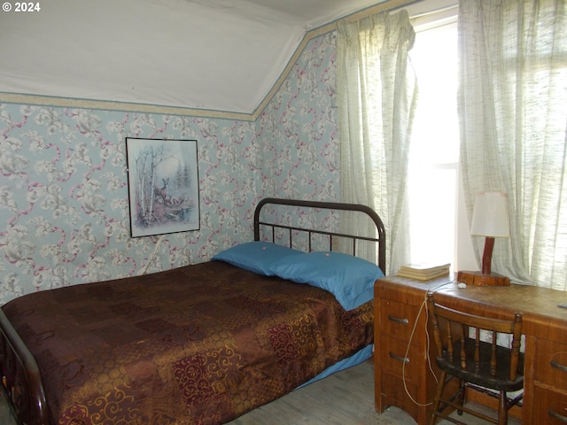 bedroom featuring vaulted ceiling and hardwood / wood-style flooring