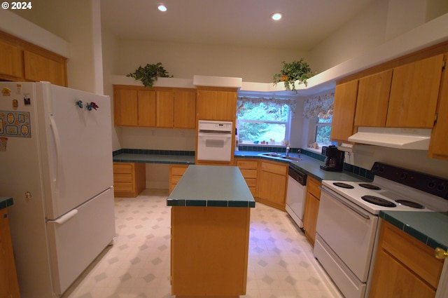 kitchen with sink, white appliances, tile countertops, and a kitchen island