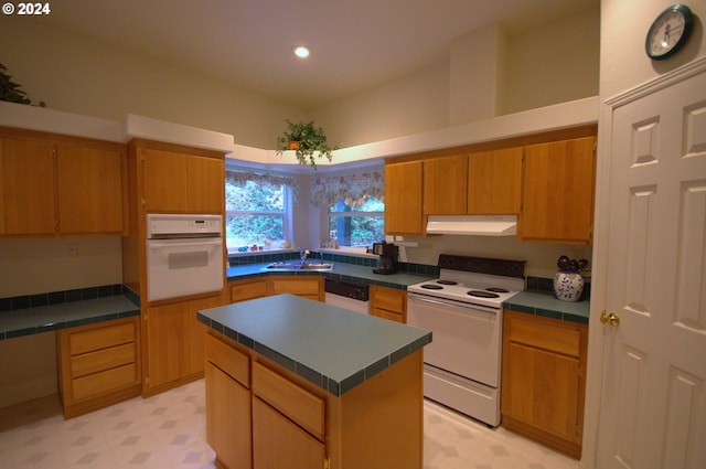 kitchen featuring tile counters, sink, white appliances, and a kitchen island