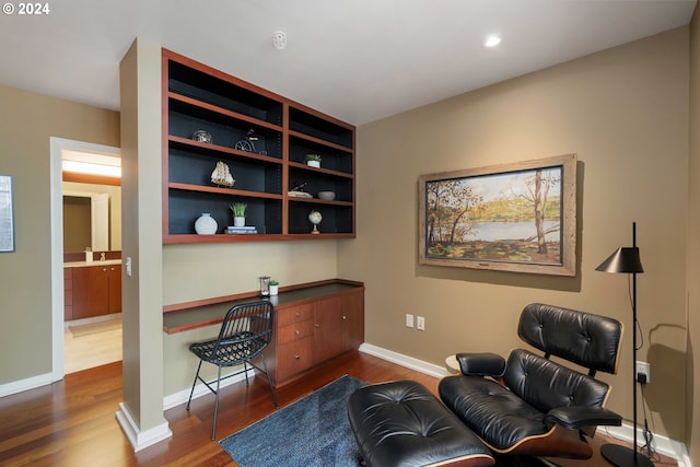 sitting room featuring hardwood / wood-style flooring and built in desk