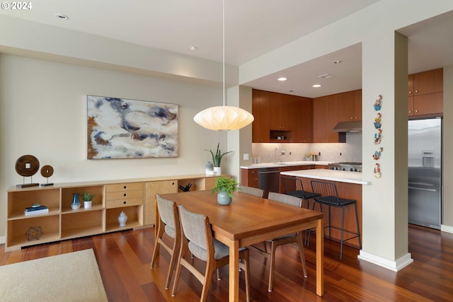 dining room featuring sink and dark wood-type flooring