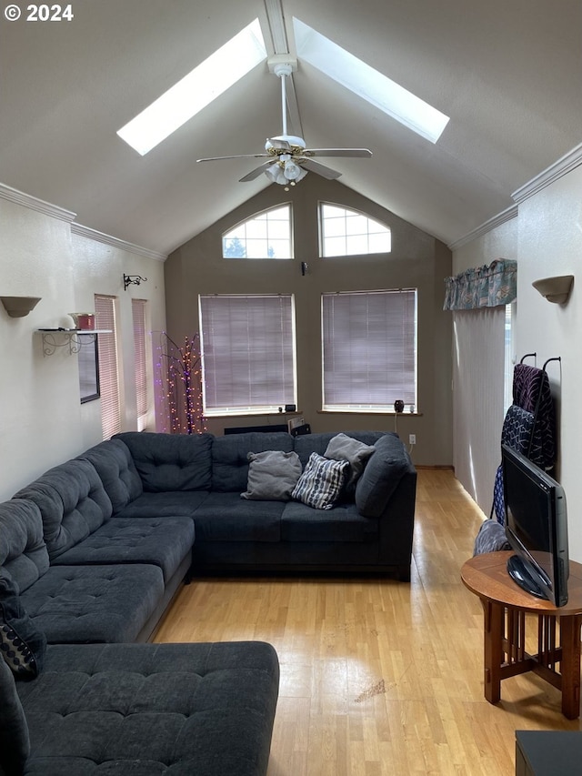 living room featuring lofted ceiling with skylight, ornamental molding, and light hardwood / wood-style floors