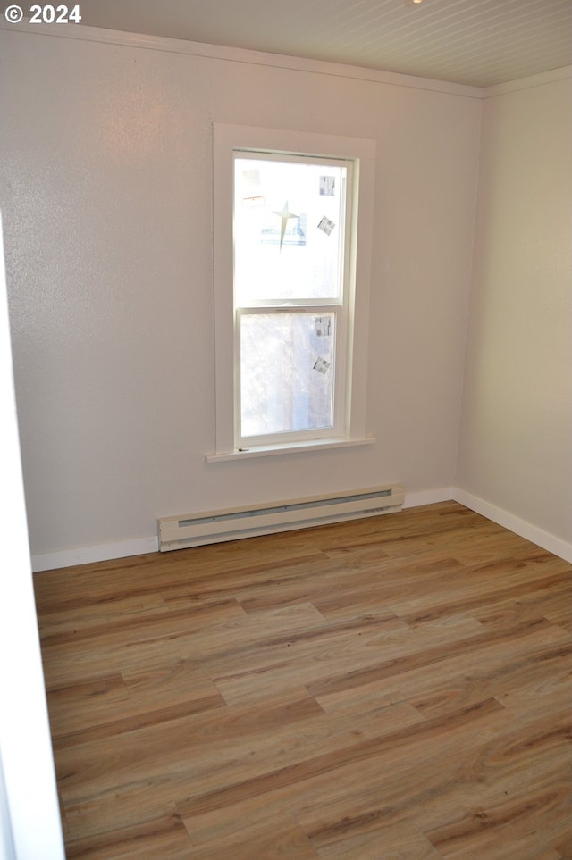 705 Couch Ave, Wallowa, OR 97885 - spare room featuring a baseboard heating unit, crown molding, light wood-type flooring, and baseboards