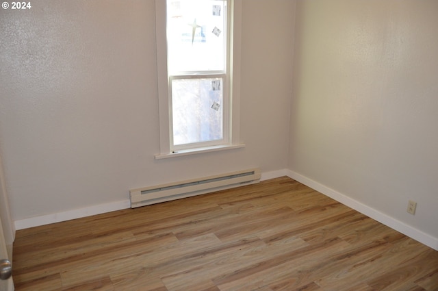 705 Couch Ave, Wallowa, OR 97885 - empty room featuring a baseboard heating unit, light wood-style floors, and baseboards
