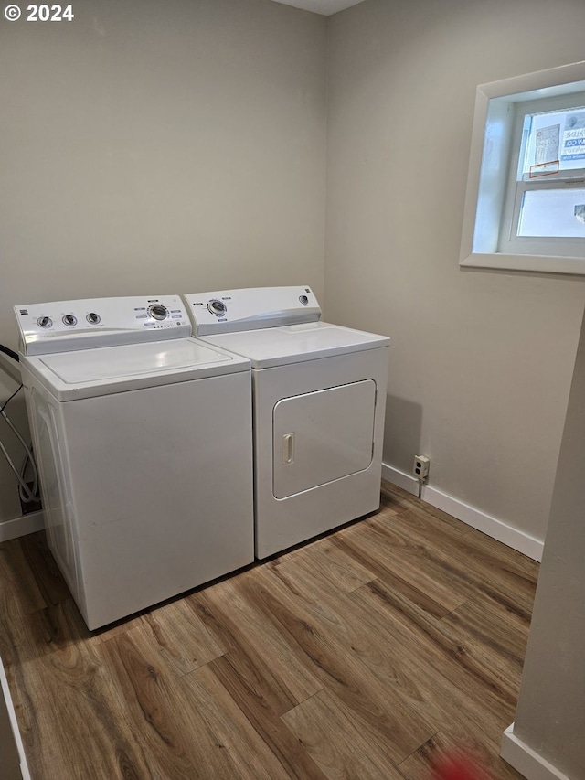 clothes washing area with dark hardwood / wood-style floors and washing machine and clothes dryer