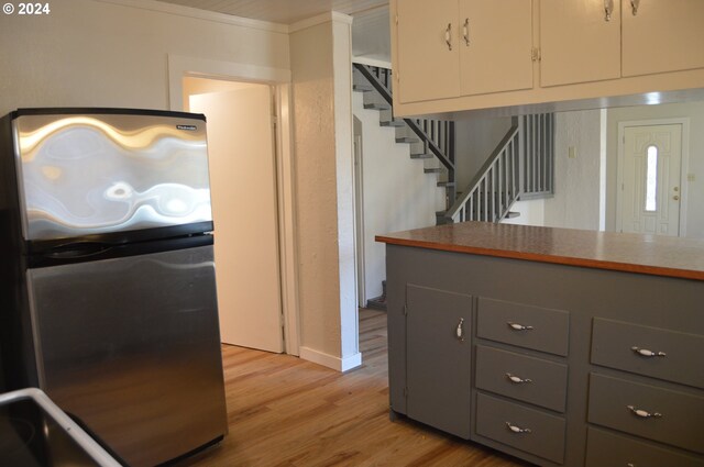 705 Couch Ave, Wallowa, OR 97885 - kitchen with freestanding refrigerator, gray cabinets, light wood-style flooring, white cabinets, and baseboards