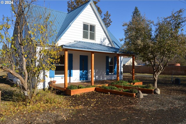 705 Couch Ave, Wallowa, OR 97885 - view of front of property with metal roof, a vegetable garden, and covered porch