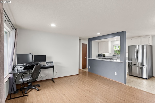 office area with a textured ceiling and light tile floors