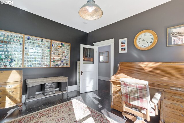 bedroom with dark wood finished floors and baseboards