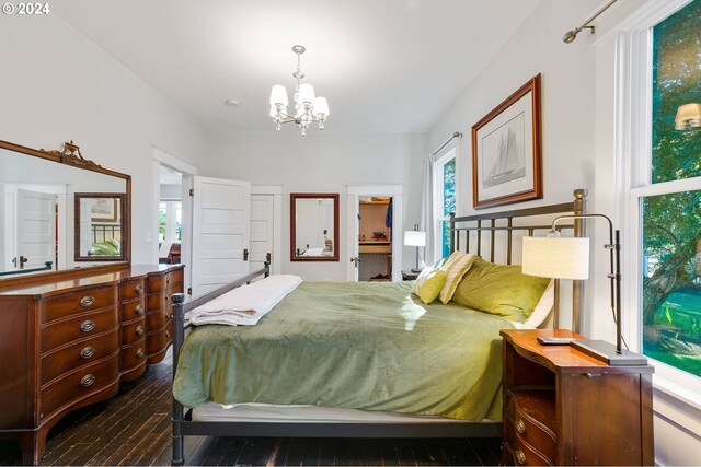 bedroom with dark wood-style flooring and a notable chandelier