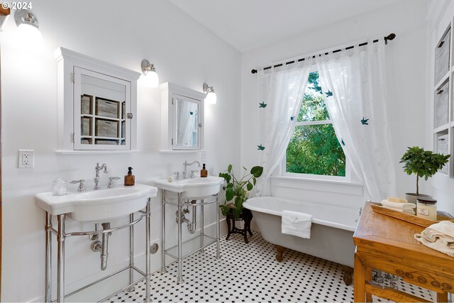 full bathroom with a freestanding tub and tile patterned floors